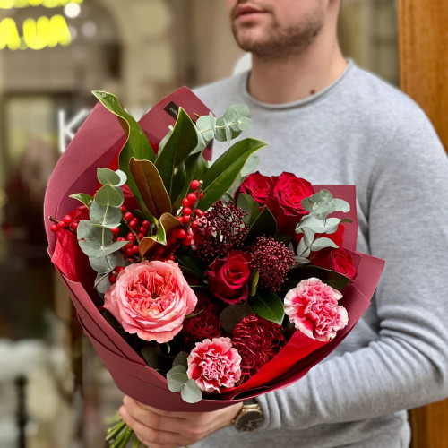 Red bouquet with roses, ilex and exotic leucospermum «Ardent look»