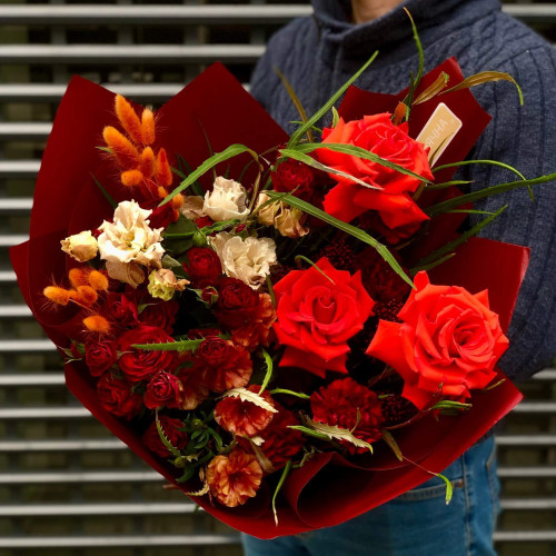 Bright bouquet with red roses, interesting ranunculus and eustoma «Fiery fox»