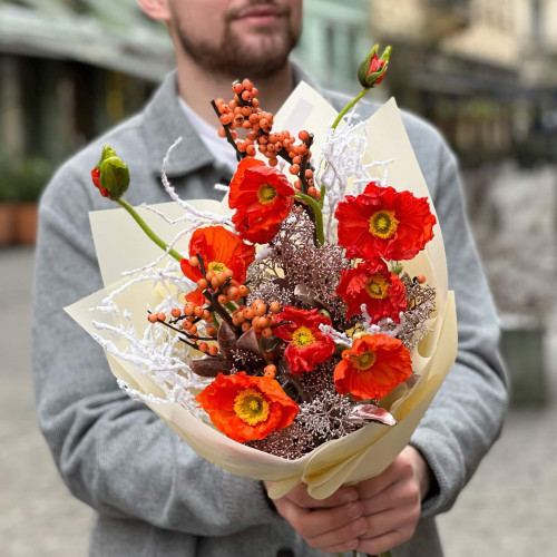 Bright orange bouquet of papaver and ilex with snow elements «Christmas light»