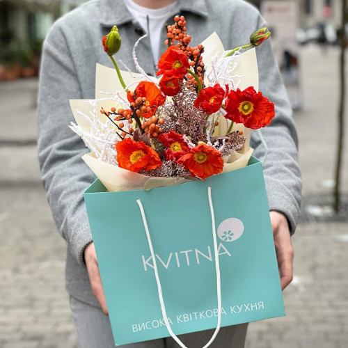 Bright orange bouquet of papaver and ilex with snow elements «Christmas light»