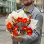 Bright orange bouquet of papaver and ilex with snow elements «Christmas light»