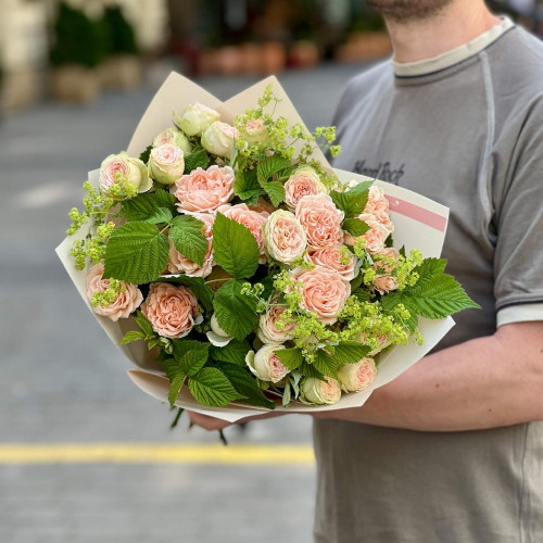 Lush bush rose in a bouquet with alchemilla and raspberry greenery «Orange Mousse»